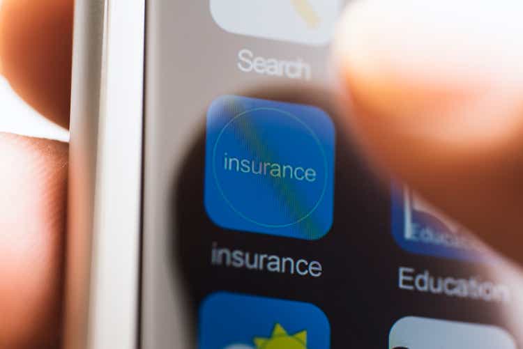 Hand touching insurance app icon on touchscreen